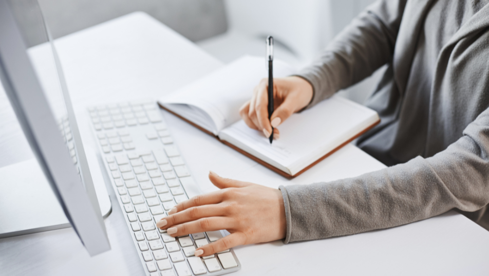 Copywriter al lavoro tra computer, pianificazione dei contenuti e scrittura di appunti professionali.