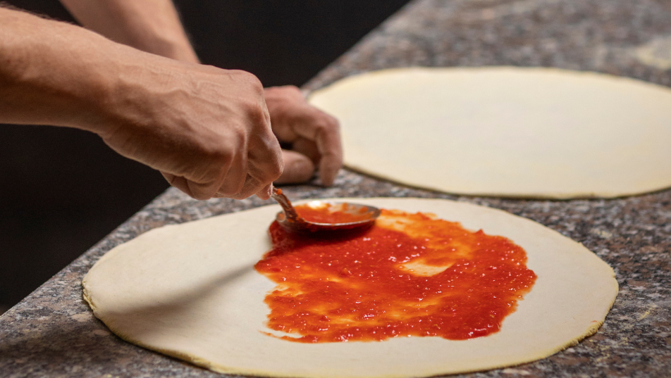Pizzaiolo durante la stesura di un impasto